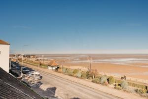 a view of a beach and the ocean from a building at Sunny Seaside Paradise in Cleethorpes