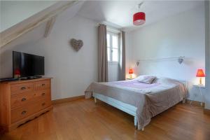 a bedroom with a bed and a tv on a dresser at SPA et SAUNA privatifs in Chémery