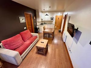 ein Wohnzimmer mit Sofa und Tisch in der Unterkunft Lotila Flats Cuirgu in Felechosa