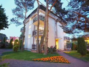 a large white building with a tree in front of it at Mobile Home in Rogowo near Baltic Beach in Mrzeżyno
