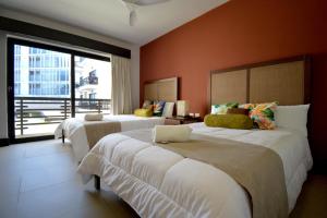 ein Hotelzimmer mit zwei Betten und einem großen Fenster in der Unterkunft Awesome apartment at Aldea Thai Beachfront in Playa del Carmen + 201 Fotos