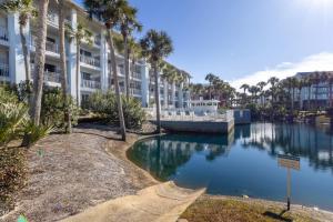 a large apartment building with palm trees and a canal at Gulf Place Cabanas in Santa Rosa Beach