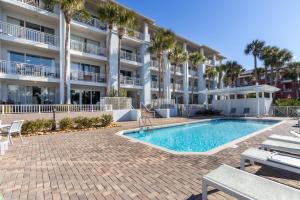 a swimming pool in front of a building with palm trees at Gulf Place Cabanas in Santa Rosa Beach