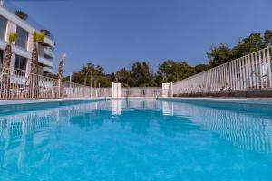 a swimming pool with blue water in front of a building at BellaMar Luxury Apartment in Marbella with amenities in Marbella