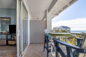a balcony with a table and chairs and the ocean at Gulf Place Cabanas in Santa Rosa Beach
