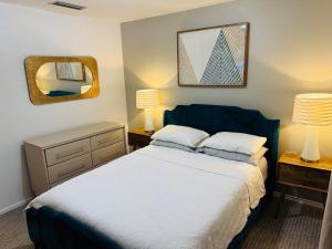 a bedroom with a bed with two lamps and a mirror at Private 2 bedroom duplex in Stafford