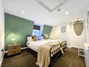 a bedroom with a bed and a green wall at The Seaside Snug in Brighton & Hove