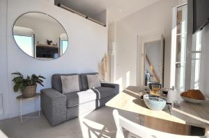 un soggiorno con tavolo, sedia e specchio di MENTON # MONACO - F1 GP - 4 PERSONS - SEA VIEW - NEW - PARKING - CLIM - PREMIUM - BEACH and SUN a Mentone