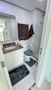 a bathroom with a toilet and a sink and a shower at Apart completo RESORT Pé na Areia RECREIO in Rio de Janeiro