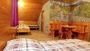 una camera con un letto e un tavolo in una cabina di Koliba-Juřena a Frenštát pod Radhoštěm
