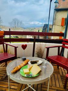 a plate of cheese and bread on a table on a balcony at Charmante maison au coeur d'un village auvergnat in Saint-Diéry +61 photos