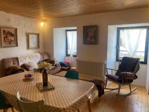 a living room with a table and a couch at Charmante maison au coeur d'un village auvergnat in Saint-Diéry +63 photos