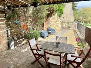 a patio with a table and chairs and a stone wall at La Maisonnette de Bédoin Mont Ventoux - Self Check In in Bédoin