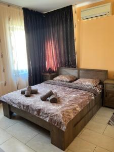 a bedroom with a bed with two slippers on it at Guesthouse Zornitsa in Hisarya