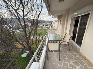 a balcony with a table and chairs and a tree at Korelis Apartments in Ayia anna