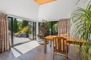 Un comedor con mesa de madera y puertas de cristal. en Mountain View Retreat - Wanaka Holiday Home, en Wanaka