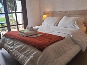 a large white bed with a towel on it at Complejo Oceanico in Punta Del Diablo +40 photos