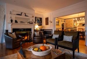 a living room with chairs and a fireplace at Sand Bar Cottage Inn in Bar Harbor +80 photos