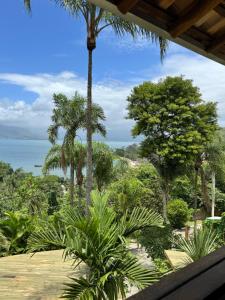 ein Blick auf das Meer von einem Resort mit Palmen in der Unterkunft Suíte Deluxe com vista para Ilhabela in São Sebastião + 6 Fotos