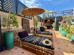 a patio with two chairs and an umbrella at Riad Dar Najwa in Marrakesh