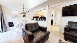 a living room with a leather chair and a table at Walk to Canyon Lodge Ski back Modern Space in Mammoth Lakes