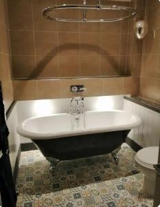 a bath tub in a bathroom with a toilet at Quirky house in winchester in Winchester
