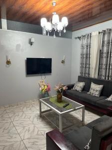 a living room with a couch and a tv at Residence Colette in Douala