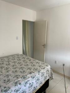 una camera da letto con un letto con copriletto floreale di Apartamento para o carnaval cris a Salvador