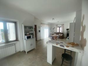 a kitchen with a table and a living room at Casa LorEnzo in Manziana +7 photos
