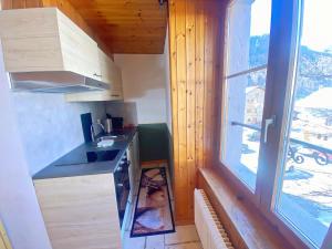 a small kitchen with a sink and a window at Studio charmant en plein centre in Evolène