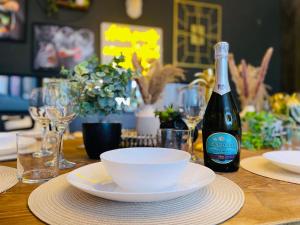 a bottle of wine sitting on a table with plates and bowls at Stag Do accommodation, central Bournemouth in Bournemouth +15 photos