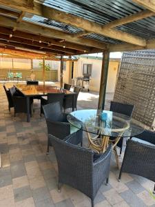 eine Terrasse mit einem Glastisch und Stühlen in der Unterkunft Cottage in Barmera in Barmera