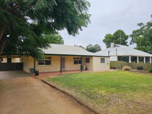 a large yellow house with a yard at Cottage in Barmera in Barmera