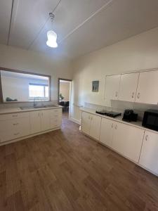 an empty kitchen with white cabinets and a sink at Cottage in Barmera in Barmera +6 photos