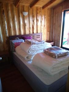 two twin beds in a room with wooden walls at Cabaña Tres Espinos Alto in Valdivia
