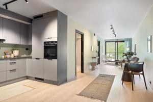 a kitchen with white cabinets and a dining room at Modern apartment with a view and parking in Tromsø