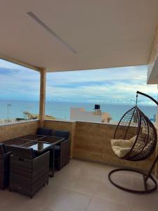 a patio with a hammock and a view of the ocean at Filocsenia luxury suite in Tsoutsouros +46 photos