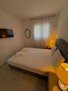 a bedroom with a large white bed and a window at Filocsenia luxury suite in Tsoutsouros