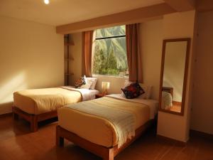 a bedroom with two beds and a large mirror at Ayllu B&B Ollantaytambo in Ollantaytambo +104 photos