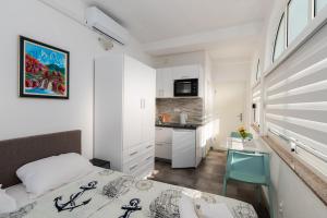 a small bedroom with a bed and a kitchen at House Santro in Baška Voda