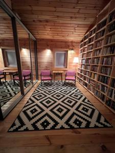 a library with two purple chairs and a rug at Sosenkowe Zacisze in Ciche