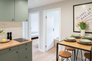 a kitchen with a island with a table and stools at Chmielna Central Apartments in Warsaw