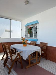 a dining room with a table and chairs with flowers on it at Chalet Grande Margarita, 75 in El Puerto de Santa María