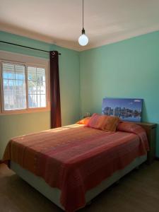 a bedroom with a bed with a red blanket at Chalet Grande Margarita, 75 in El Puerto de Santa María