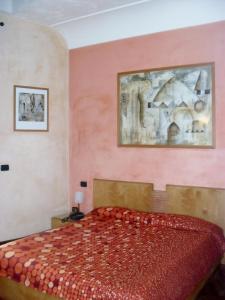 a bedroom with a red bed and a painting on the wall at Hotel Clarean in Naples