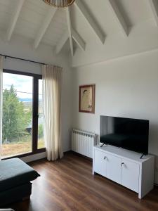 un soggiorno con TV e una grande finestra di Lenga Hogar a El Calafate