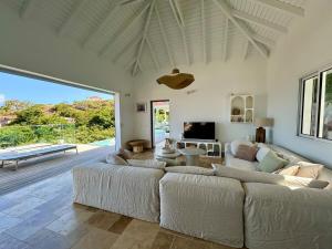 a living room with a large couch and a table at CARIOCA vue PAIN DE SUCRE in Terre-de-Haut