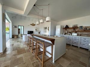 a kitchen with a large island with bar stools at CARIOCA vue PAIN DE SUCRE in Terre-de-Haut