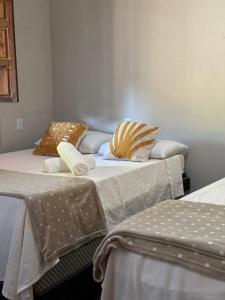 Dos camas una al lado de la otra en una habitación. en Vila Kairós, en Caraíva