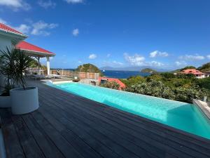a wooden deck with a swimming pool on top of a house at CARIOCA vue PAIN DE SUCRE in Terre-de-Haut